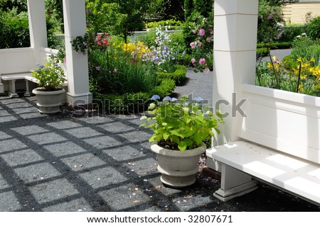 Ornamental garden and pergola. Bench, flower pots, footpath