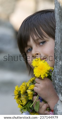 Little girl cuddles yellow flowers (dandelions) in her arms and smiles. This image is a good illustration for saying \