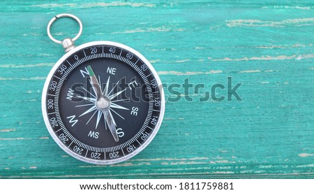 Classic round compass on green wooden vintage background as symbol of tourism with compass, travel with compass and outdoor activities with compass Stockfoto © 