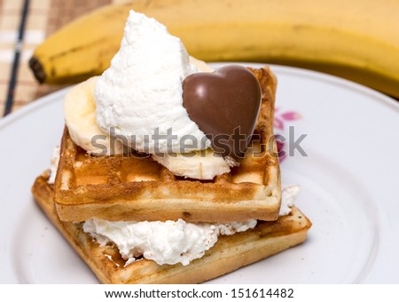 Waffles with sweet cream, chocolate and banana.