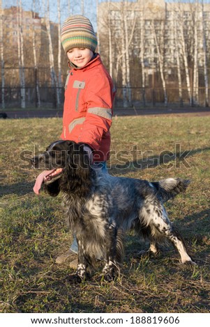 Little boy holding the hunting dog over the dog-collar