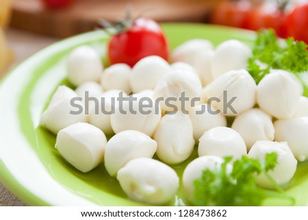 small balls of mozzarella on green plate, closeup