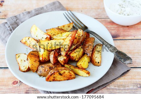 Roasted potatoes with herbs and spices, food closeup