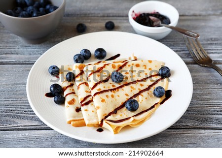 Crepes with chocolate sauce and berries,  top view