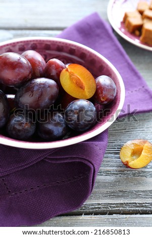 ripe and fresh plums in a bowl, side view