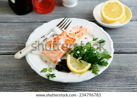 red fish with a lemon on  plate, top view