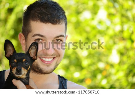 smiling man hugging his  little dog