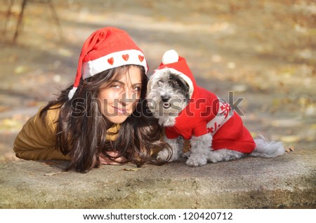 girl and dog with red christmas hats