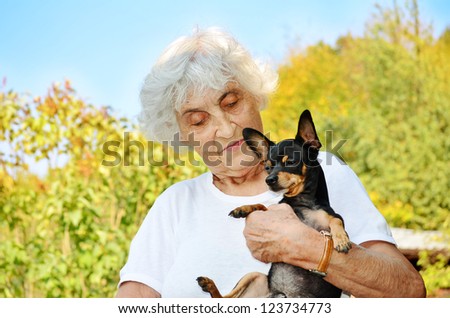 happy old woman with her dog smiling at the camera
