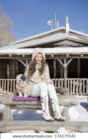 beautiful young woman enjoying the time spent with her dog in the winter  mountain