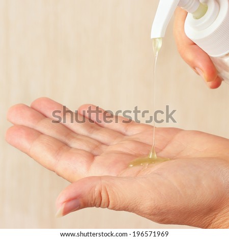 Female hands using antiseptic liquid soap close up