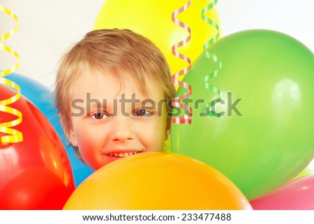 Little boy with holiday balloons and a streamer