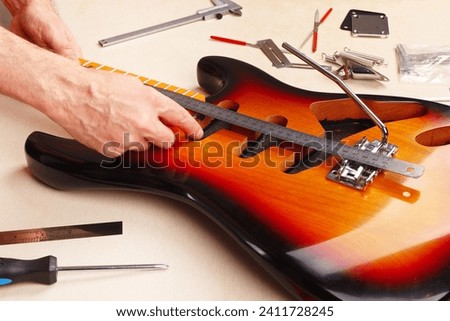 Image, Stock Photo Craftsman tuning string instrument in workshop