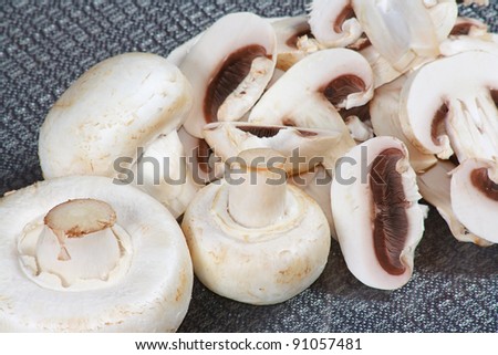 The slices of raw white champignons from grey background