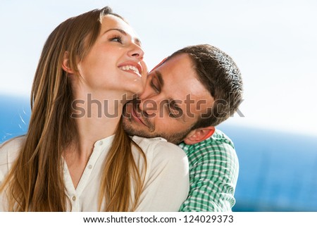 Close up portrait of young couple sharing secrets outdoors.