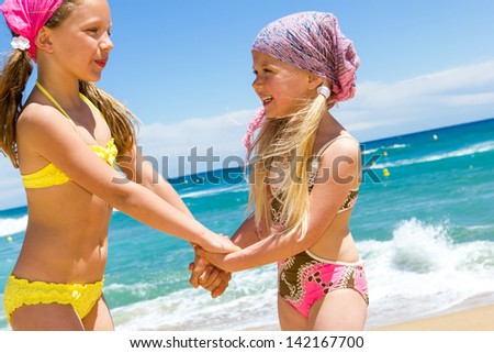 Portrait of two happy kids in swim wear at sea.