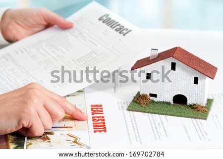 Close up of female hands reviewing real estate property documents.