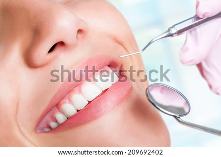 Macro close up of Human teeth with hatchet and mouth mirror