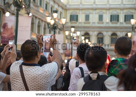 Macau, China - June 25, 2015:People watching a live show taking photos and videos in Venetian Hotel, Macao on June 25, 2015. The Venetian Hotel is one of the largest casino in the world.
