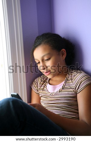 pretty biracial girl looking at her cell phone