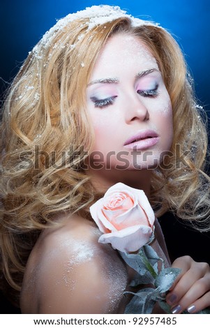 The beautiful blond girl with winter cosmetics and a rose