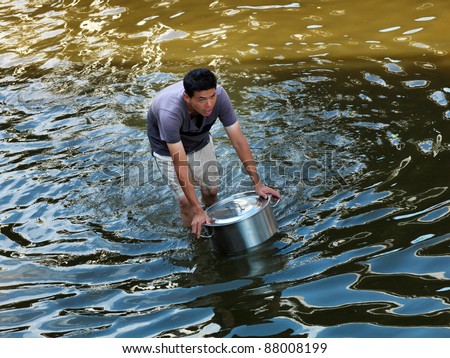 PHATHUMTRANI, THAILAND- OCTOBER 21: Man takes food for family, during the worst flooding disaster   on October 21, 2011 Rongsit Road, Phathumtrani, Thailand.