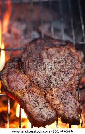 food meat -  rib eye beef steak on party summer barbecue grill with flame. Shallow dof.