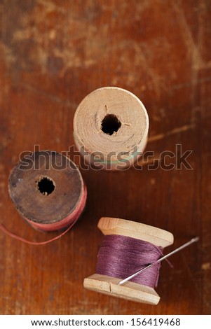 real old reels spools with color treads on old wooded background, shallow dof