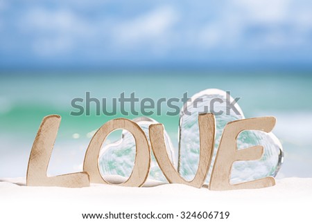 love message and glass hearts on  beach under the sun light with  ocean , beach and seascape, shallow dof