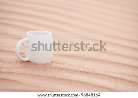 white coffee cup in sahara sand dune,  Grand Sand Sea, shallow dof