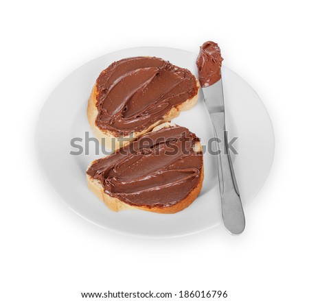 baguette slices spread with nut-choco paste on plate, isolated on white