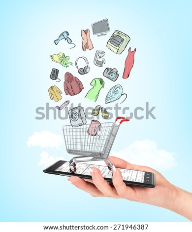On line shop concept. Female hand holding a phone on which stands empty shopping cart with colorful drawing goods. E-commerce.