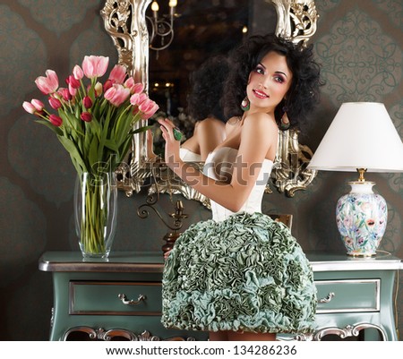 Beautiful Glamorous Woman in Retro Interior with Vase of Flowers. Reflection