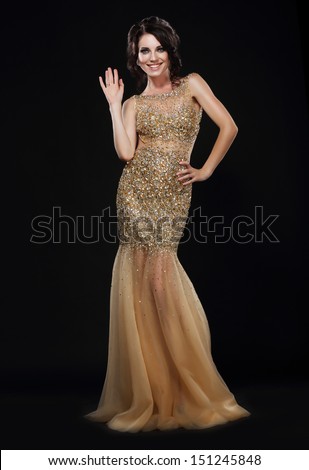 Stylishness. Well-dressed Young Woman in Long Golden Dress
