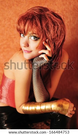 Red-haired girl wearing corset and leather pants