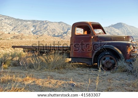 An old flatbed truck in a high desert valley.