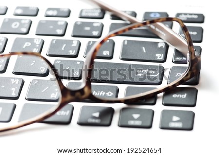 eyeglasses and computer notebook keyboard, The photo focus at enter button