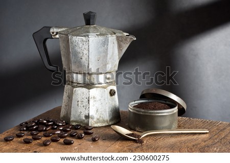 still life photography, old stove top italian espresso maker with coffee bean, coffee grind and spoon on old wood