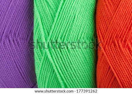 background of yarn skeins in green, orange and purple colors