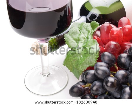 Glass of black wine and grapes on white background