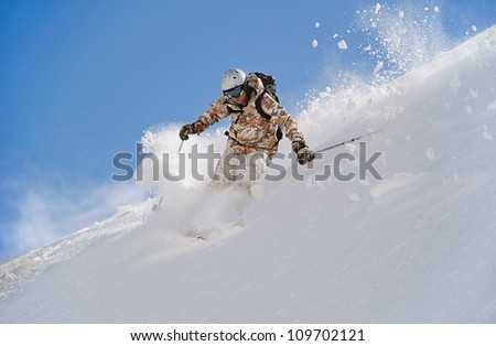 Skier in deep snow. In turn raises the snow dust.