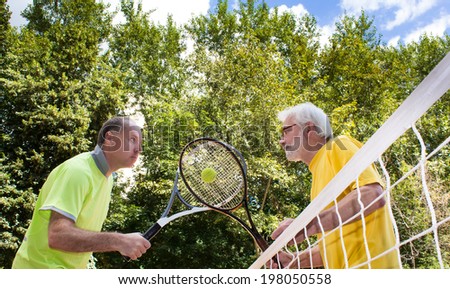 Playful beginning of the match. Tennis competitions in a bright sunny day on a background of green trees