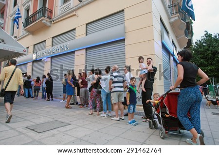 GREECE, Thessaloniki JUNE 28, 2015: Citizens line up to use an automated teller machine (ATM) outside a closed bank. Cash machines ran dry after Greeks rushed to withdraw their savings from the banks.