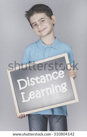Boy holding a blackboard with Distance Learning message. Cross processed image