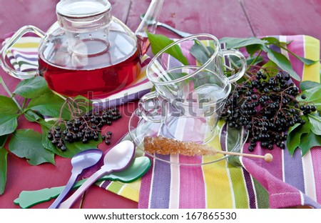 Glass cups with tea and fresh elder berries