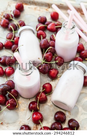 Creamy milk shake with fresh cherries on cold ice cubes