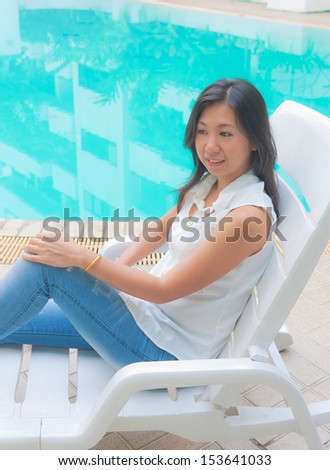 Portrait of an Asian woman relaxing on a pool chair