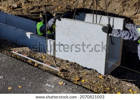 Road worker mounting U-ditch, U-shaped water channel construction the drain used as monsoon drain ストックフォト © 