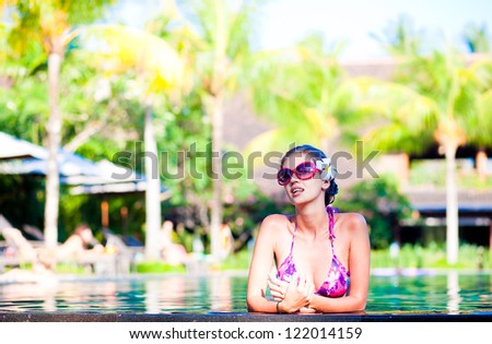 portrait of young attractive smiling woman in luxury pool