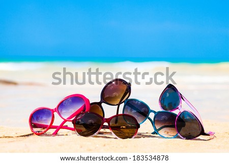 picture many sunglasses lying on tropical beach